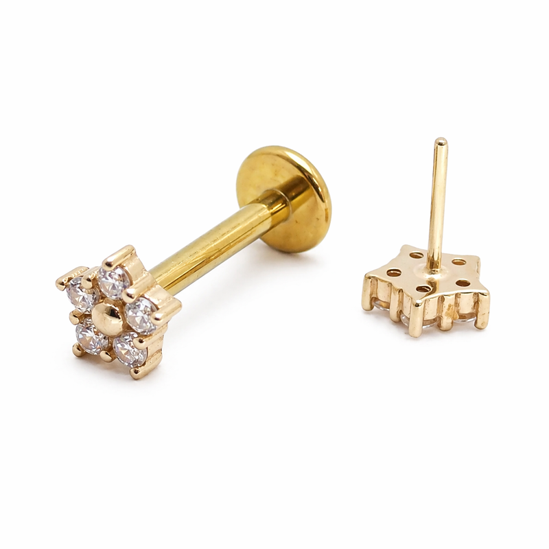 14k gold flower design titanium flatback push-fit labret piercing by Body Clickers displayed on skin.