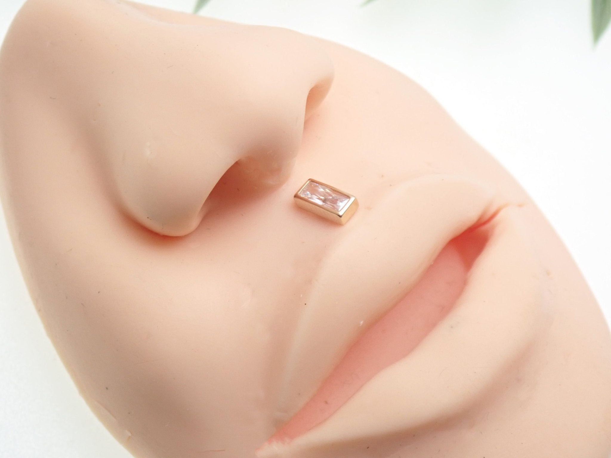 14k gold rectangle flatback push-fit piercing by Body Clickers, showcasing a sleek titanium design for comfortable wear.