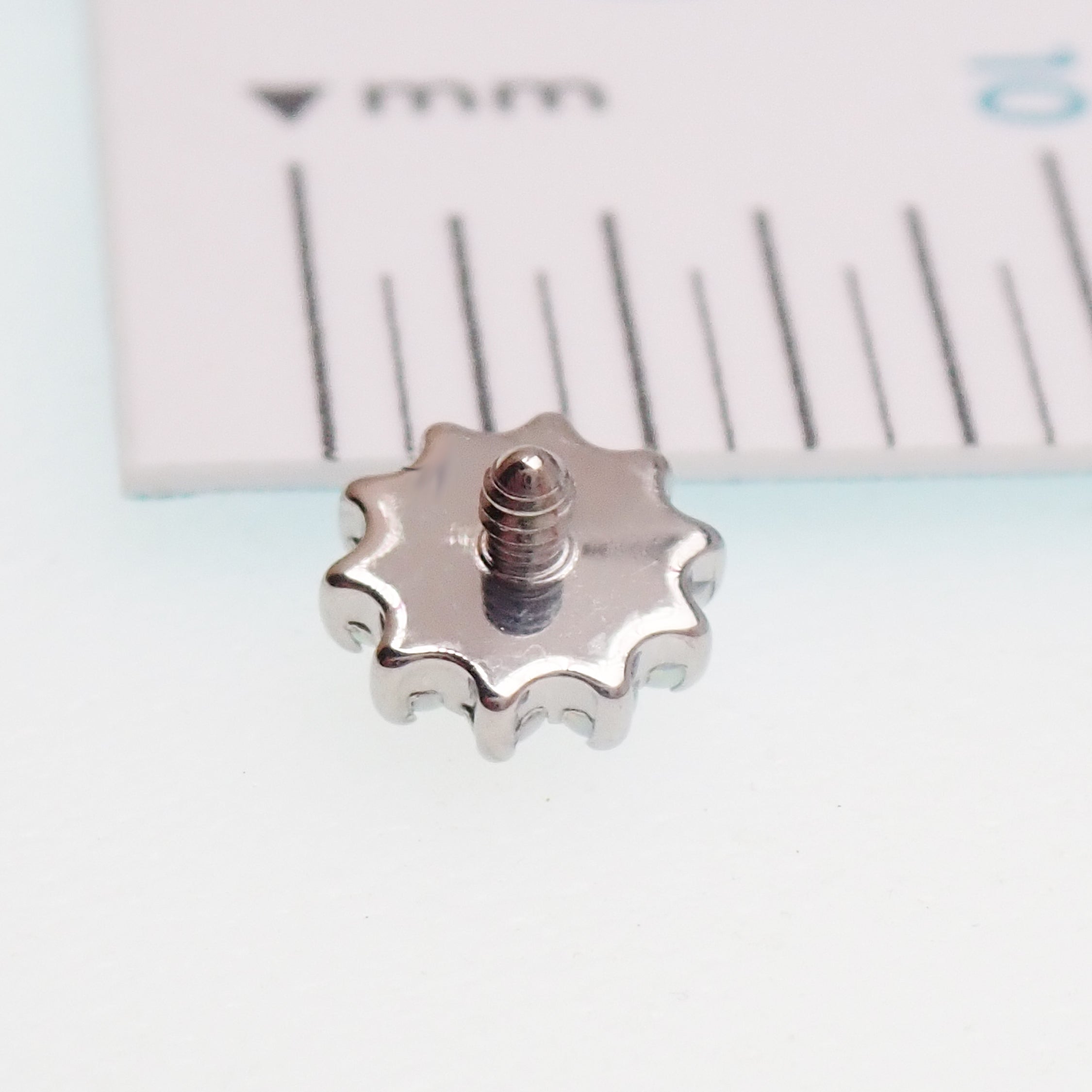 Clear CZ daisy flower dermal implant by Body Clickers, titanium, internally threaded, 14g, 1.2mm thread, visible in the image.