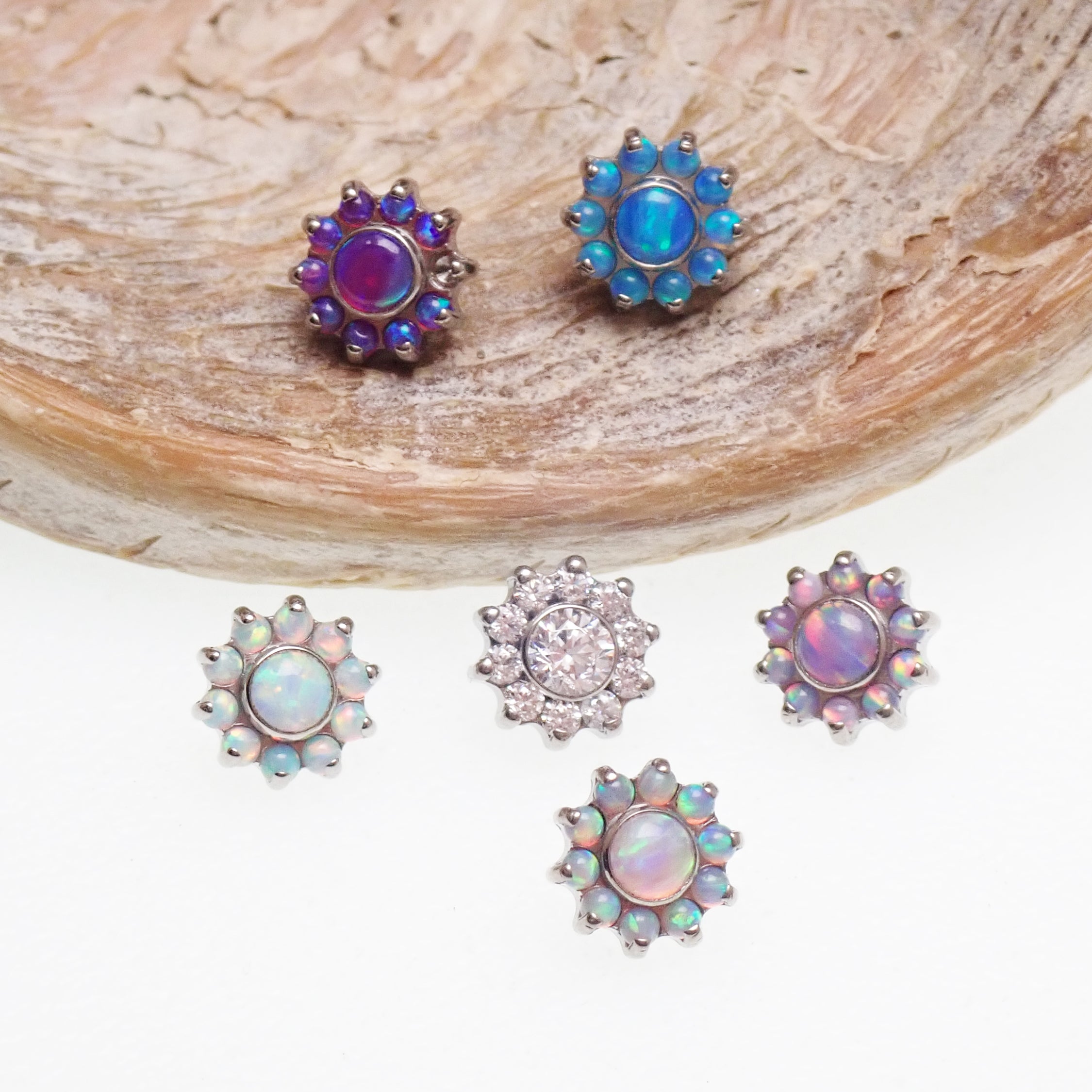 Clear CZ daisy flower dermal implant by Body Clickers, titanium internally threaded tops, 14g, 1.2mm thread, visible in image.
