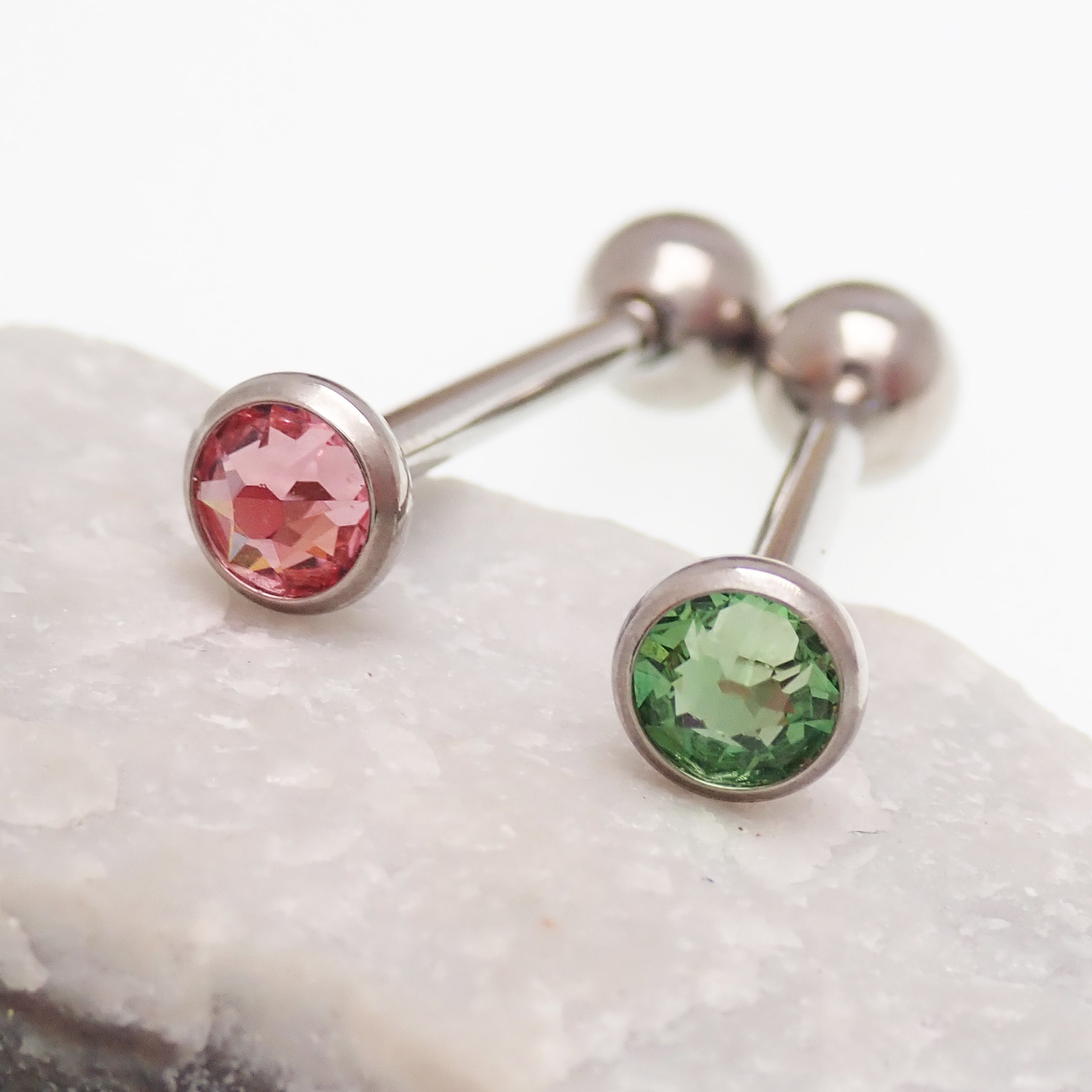 Pink or green CZ titanium tongue barbell piercing in 14g with a sleek barbell design by Body Clickers.