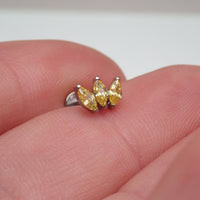 Citrine yellow CZ flatback body jewelry by Body Clickers held in hand, available in 14g, 16g, and 18g sizes.