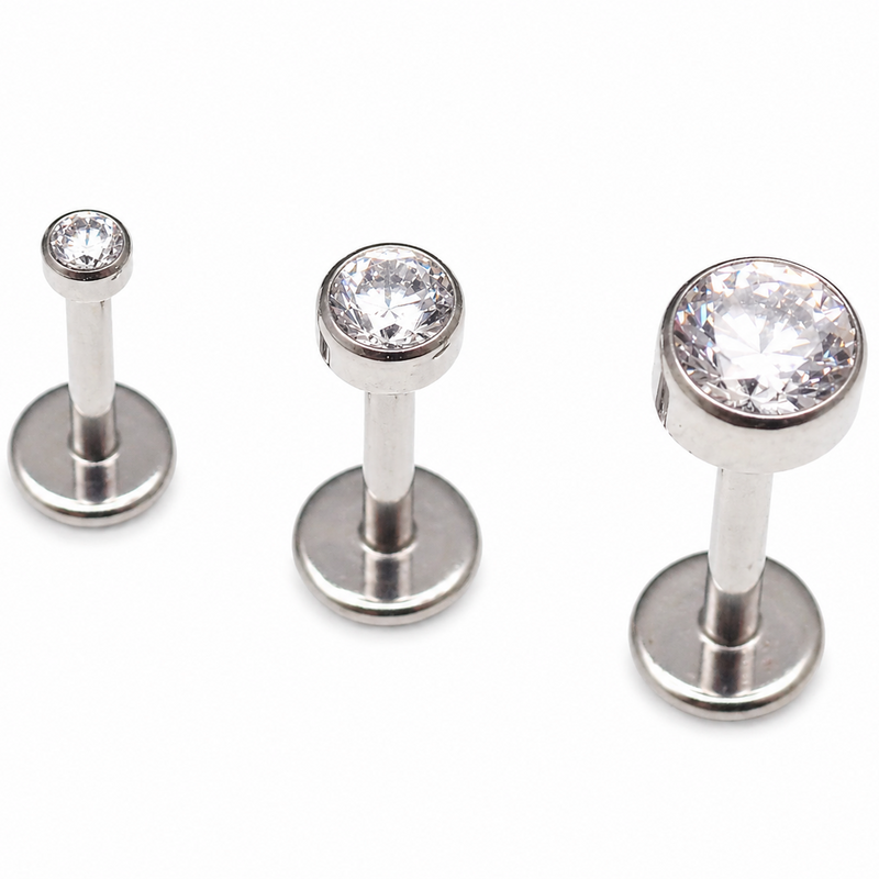 Clear CZ titanium push fit flat back body jewelry in 14g, 16g, 18g, and 20g sizes with gold accents by Body Clickers.