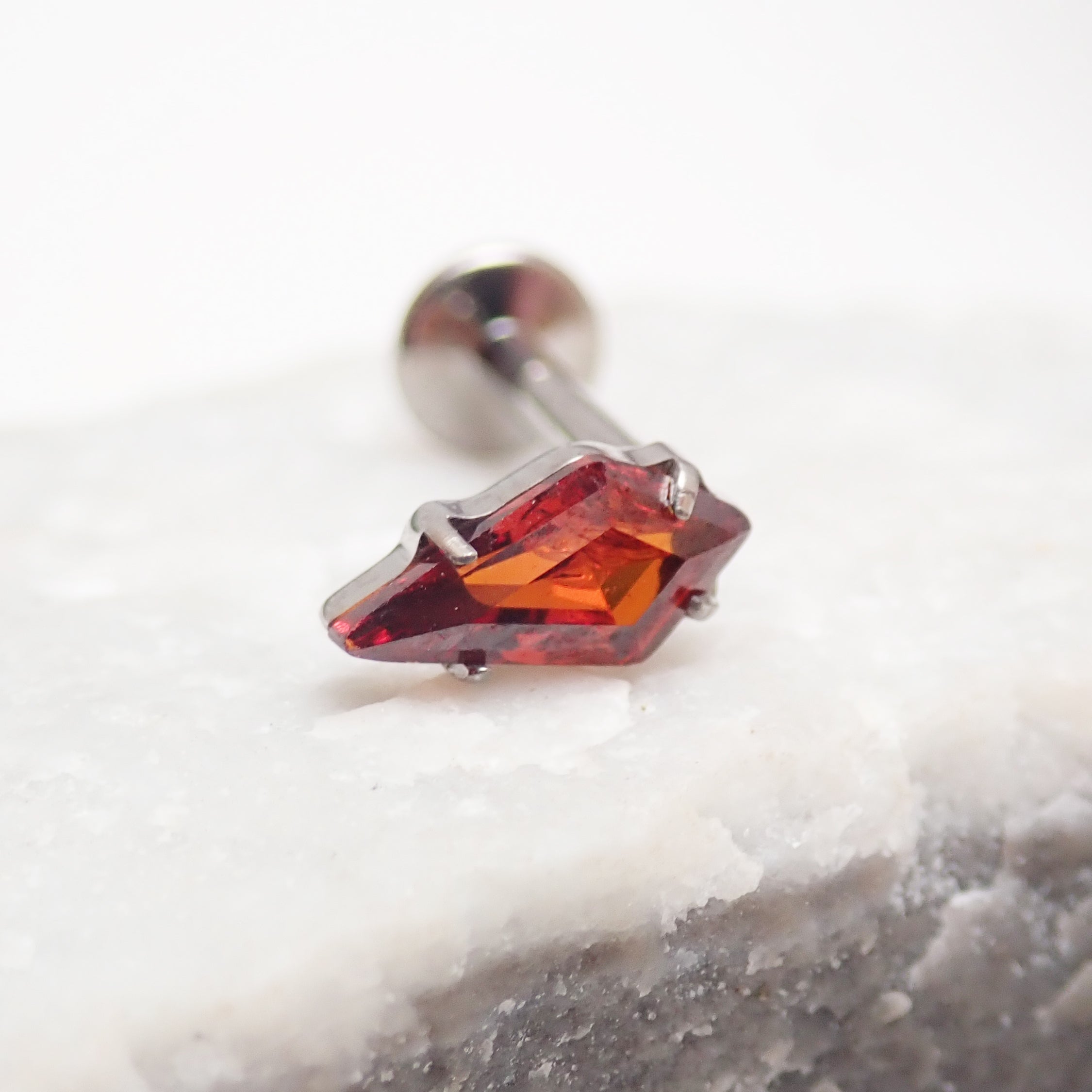 Implant grade titanium push-fit threadless piercing with a single garnet stone flatback, designed for body jewelry.
