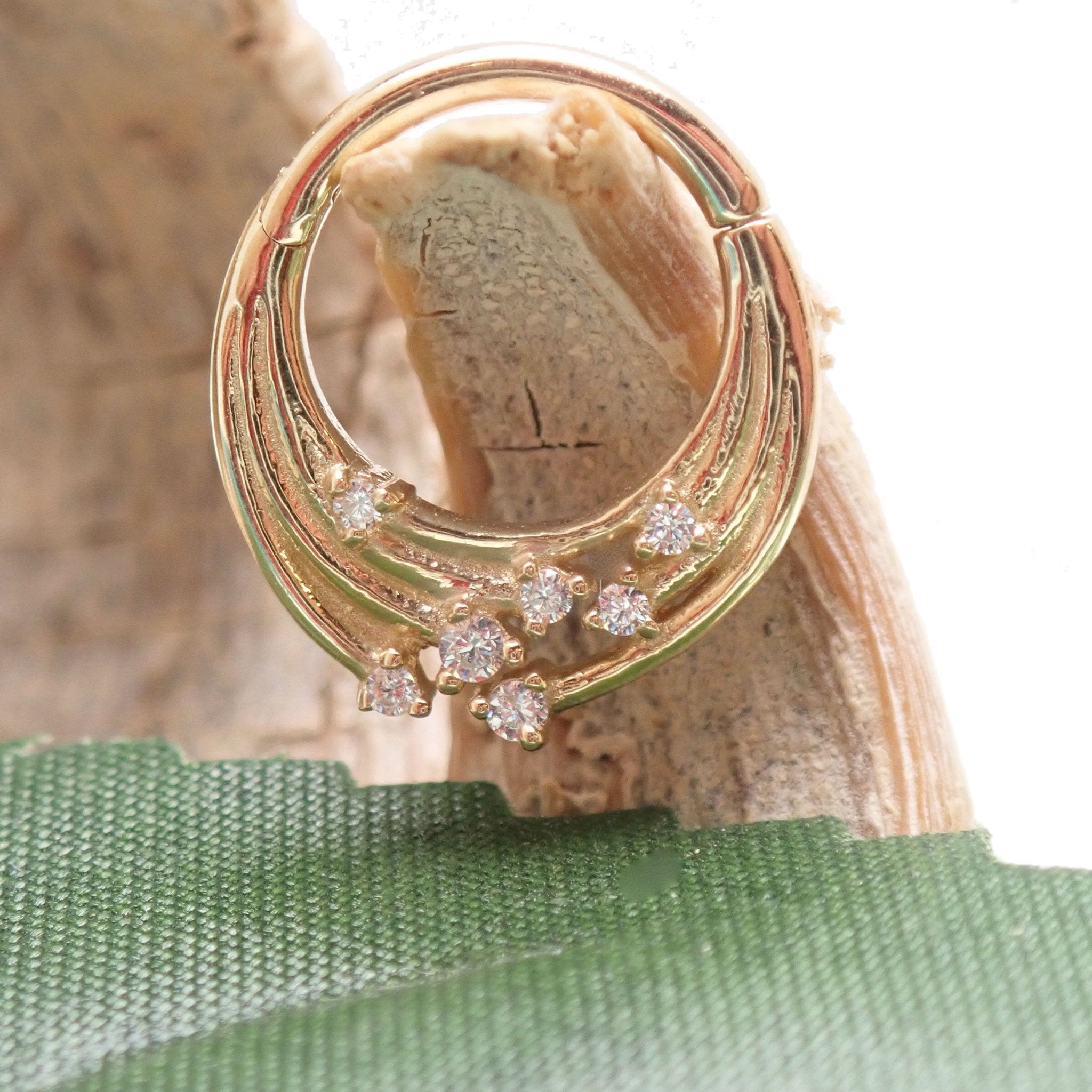 14k gold cosmic septum and daith clicker in 16g, featuring celestial designs and secure clasp for body jewelry piercing.