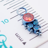 Assorted CZ charm colors in orange and teal for Body Clickers titanium body jewelry, shown in a close-up image.