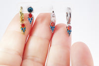 Assorted colorful cubic zirconia charm for body jewelry by Body Clickers, featuring orange and teal titanium accents.
