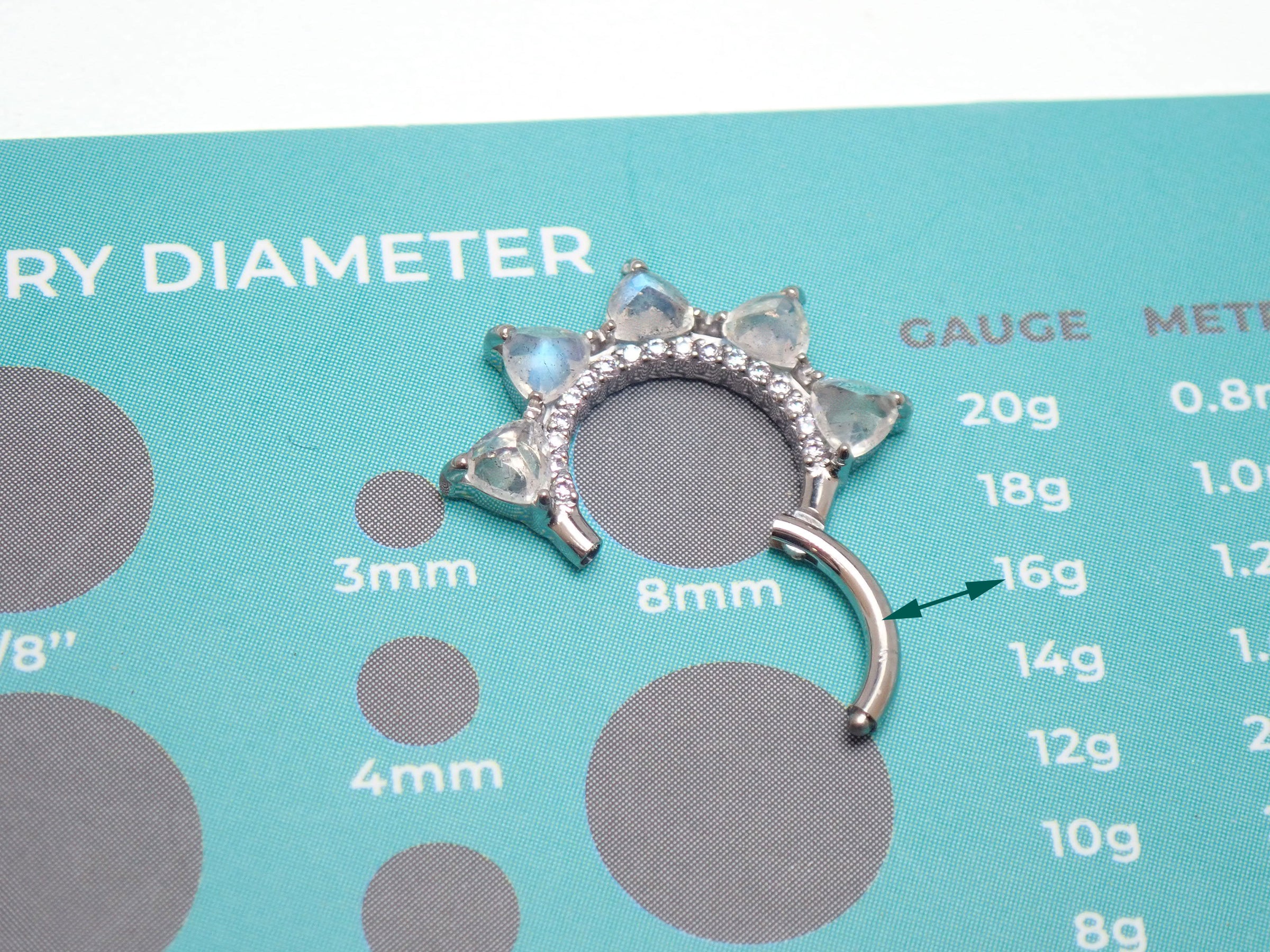 Moonstone implant grade titanium clicker jewelry in 16g size with an 8mm diameter, featuring a sleek design for body piercing.