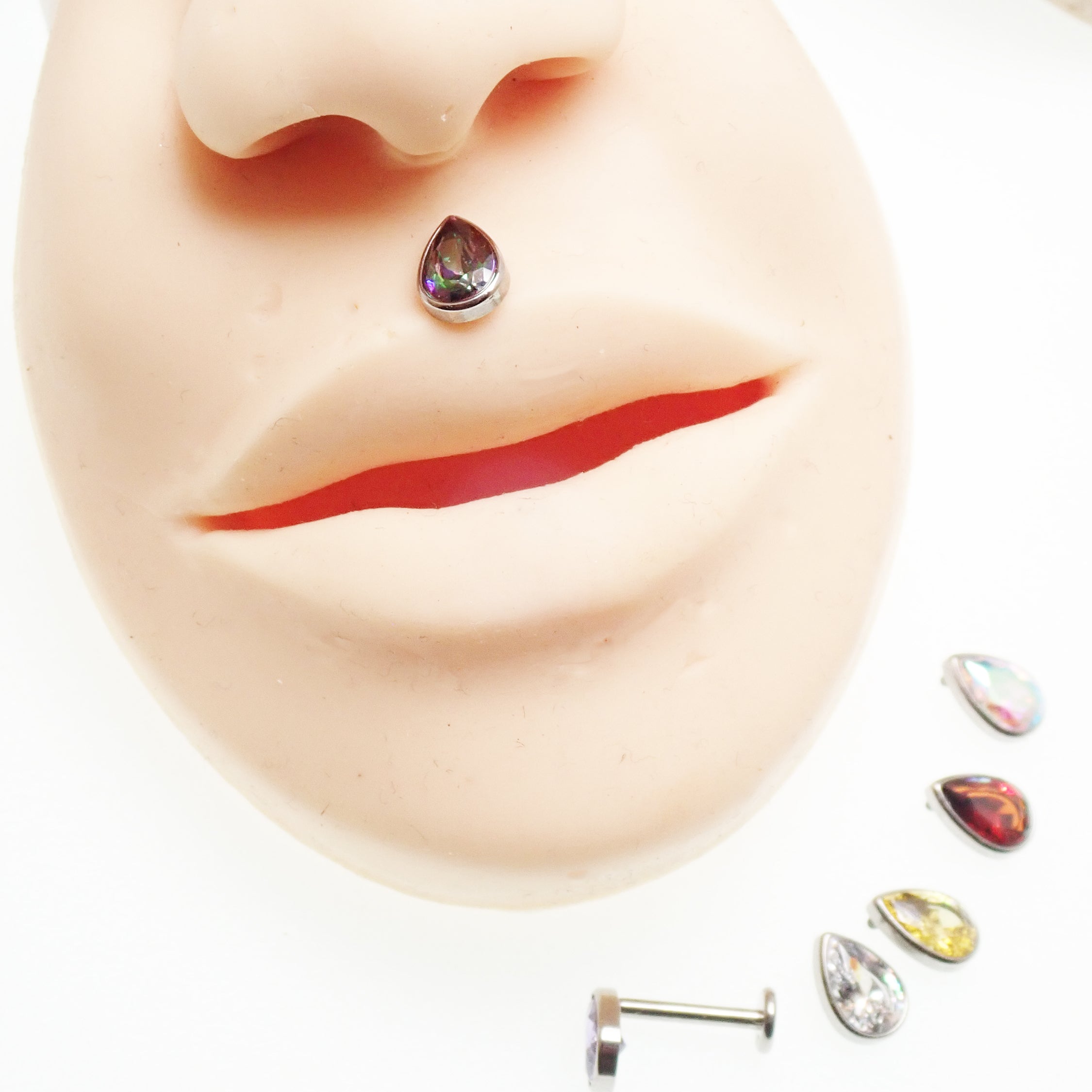 Large CZ teardrop flat back body jewelry in 14g, 16g, or 18g, featuring a garnet-colored cubic zirconia from Body Clickers.