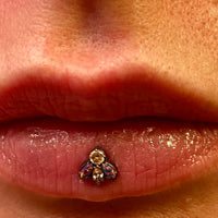 Close-up of a cute bug-shaped opal and CZ titanium dermal top body jewelry on a 14g piercing.