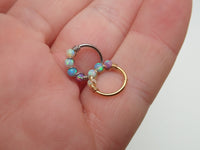 Sterling silver fire opal nose and ear hoop, 8mm, from Body Clickers Body Jewelry featuring a vibrant gemstone design.
