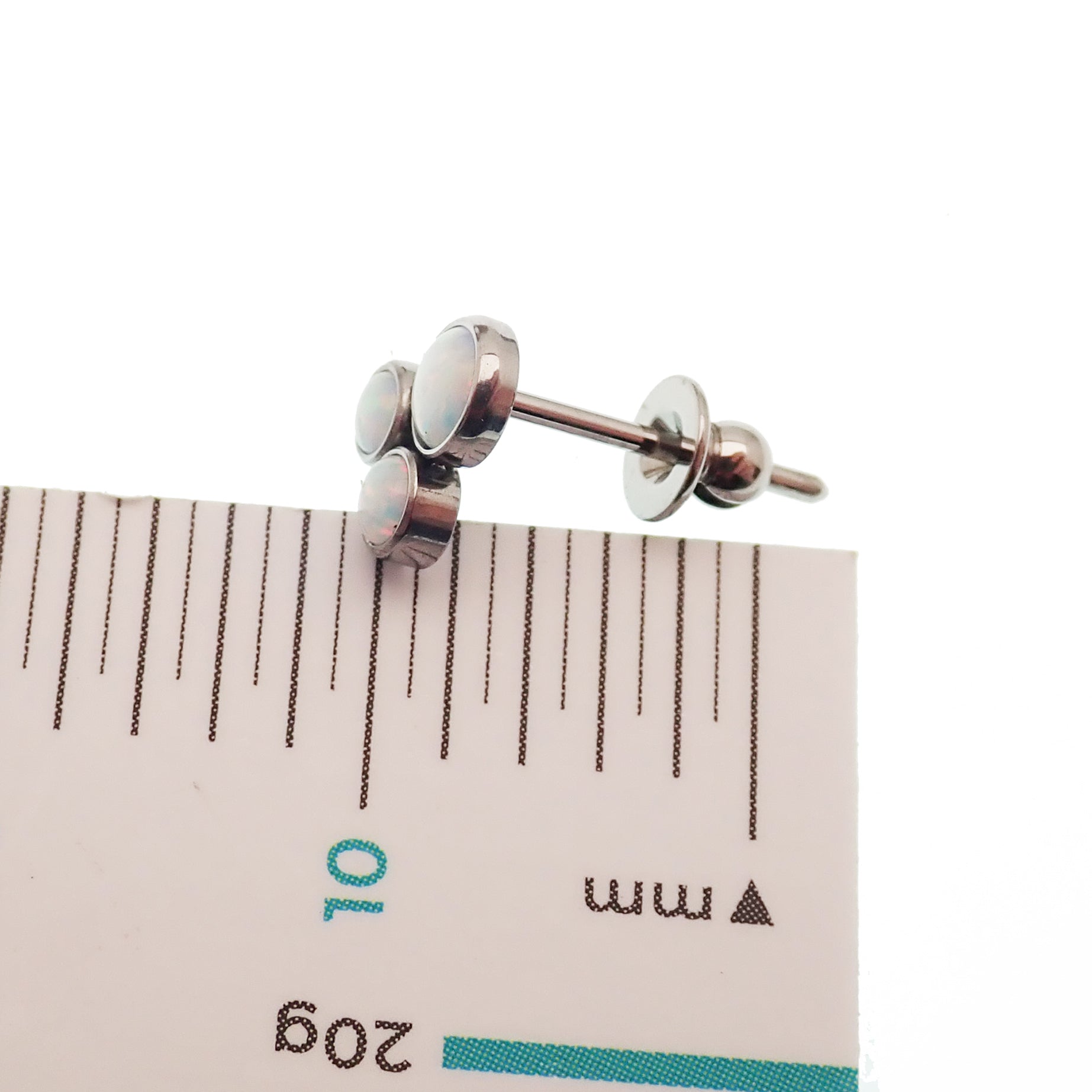 Pair of Body Clickers titanium implant earrings with white opal Trinity Fire design, 20g gauge, featuring intricate gemstone details.