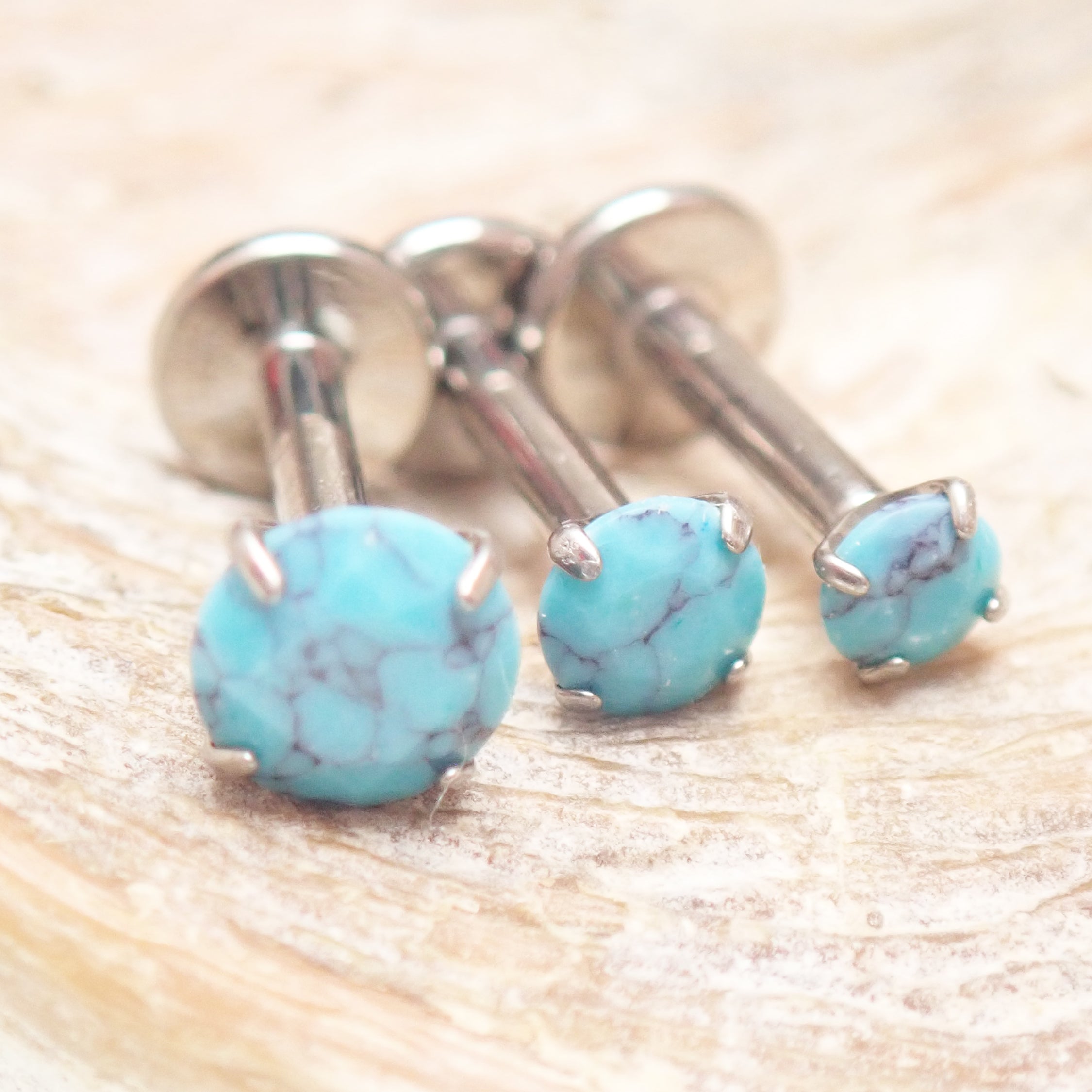 Turquoise claw set stone internally threaded titanium labret piercing earrings in 14g, 16g, and 18g sizes.
