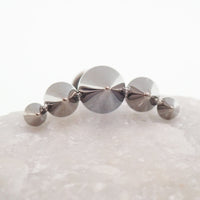 Body Clickers titanium cone spike curve earrings with flatback labret, internally threaded in 14g, 16g, and 18g sizes.