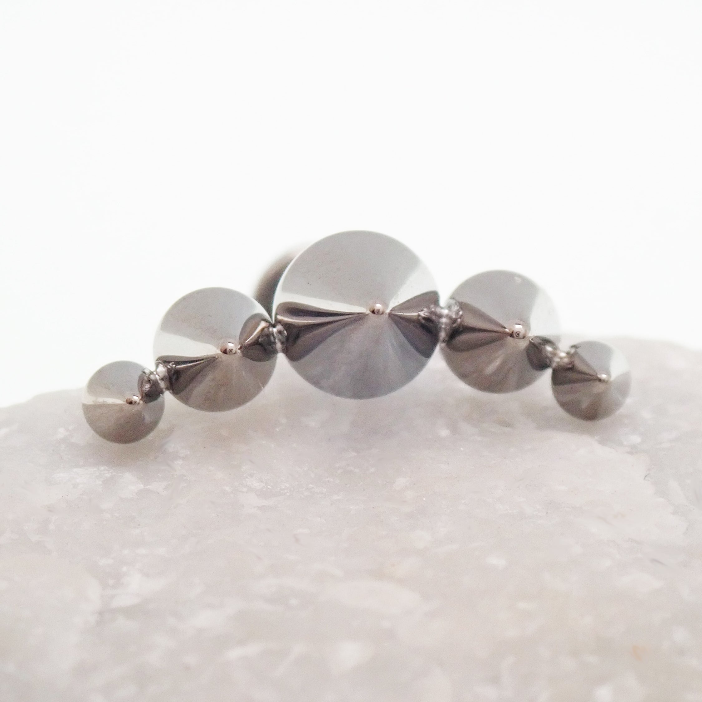 Body Clickers titanium cone spike curve earrings with flatback labret, internally threaded in 14g, 16g, and 18g sizes.