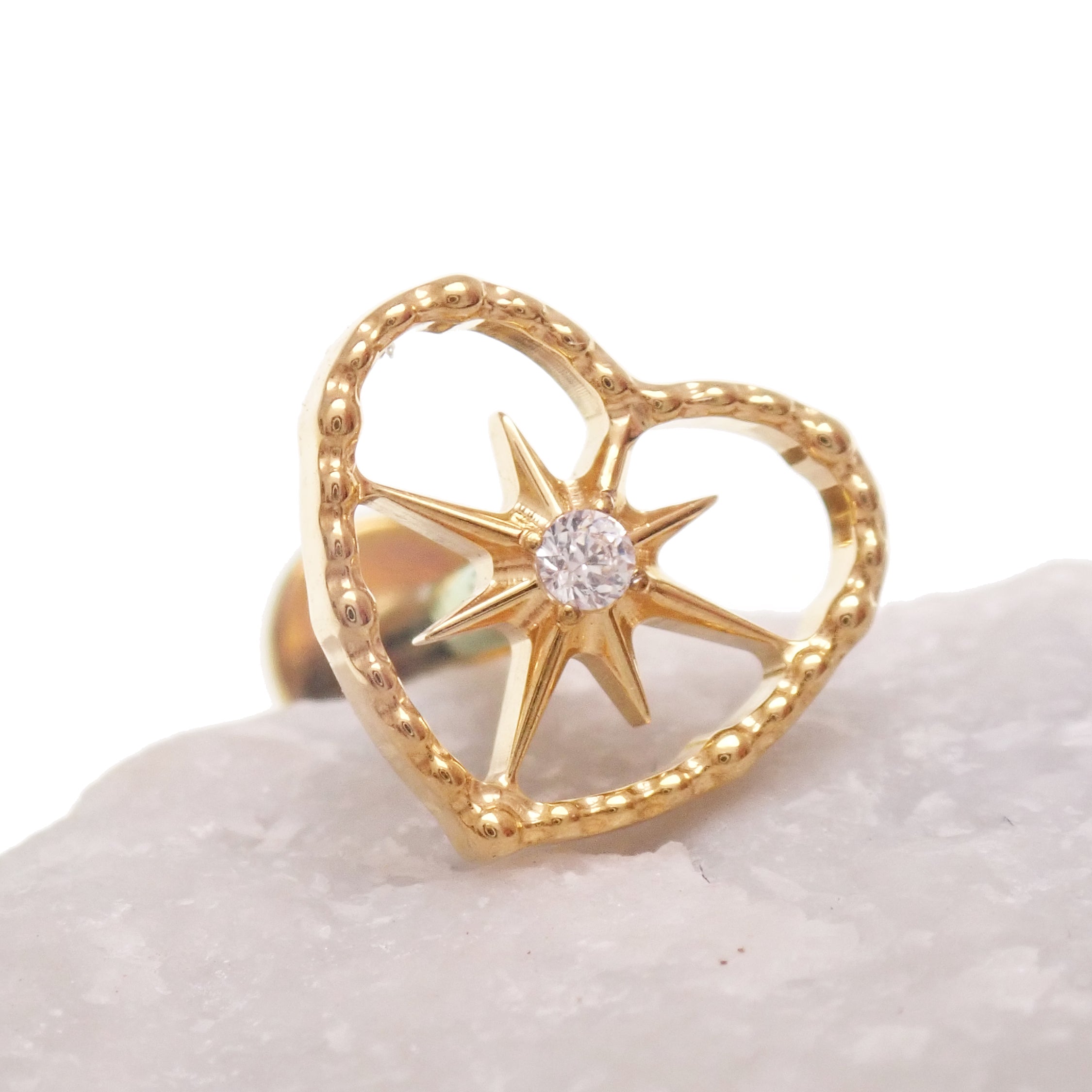 Gold heart and starburst implant titanium PVD flatback piercing earrings in 18g, 16g, and 14g, internally threaded.