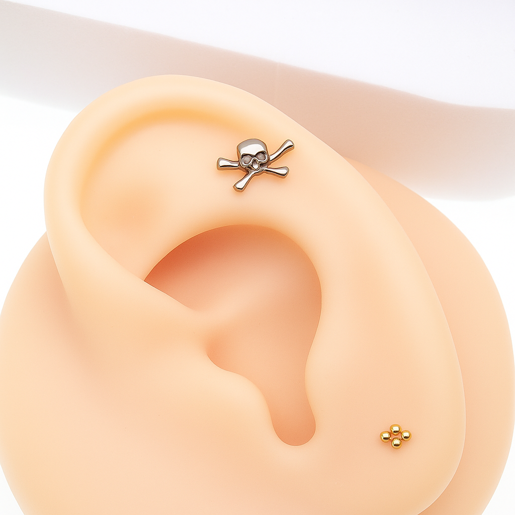 Titanium skull and crossbones flatback piercing earrings by Body Clickers, internally threaded in 14g, 16g, and 18g sizes.