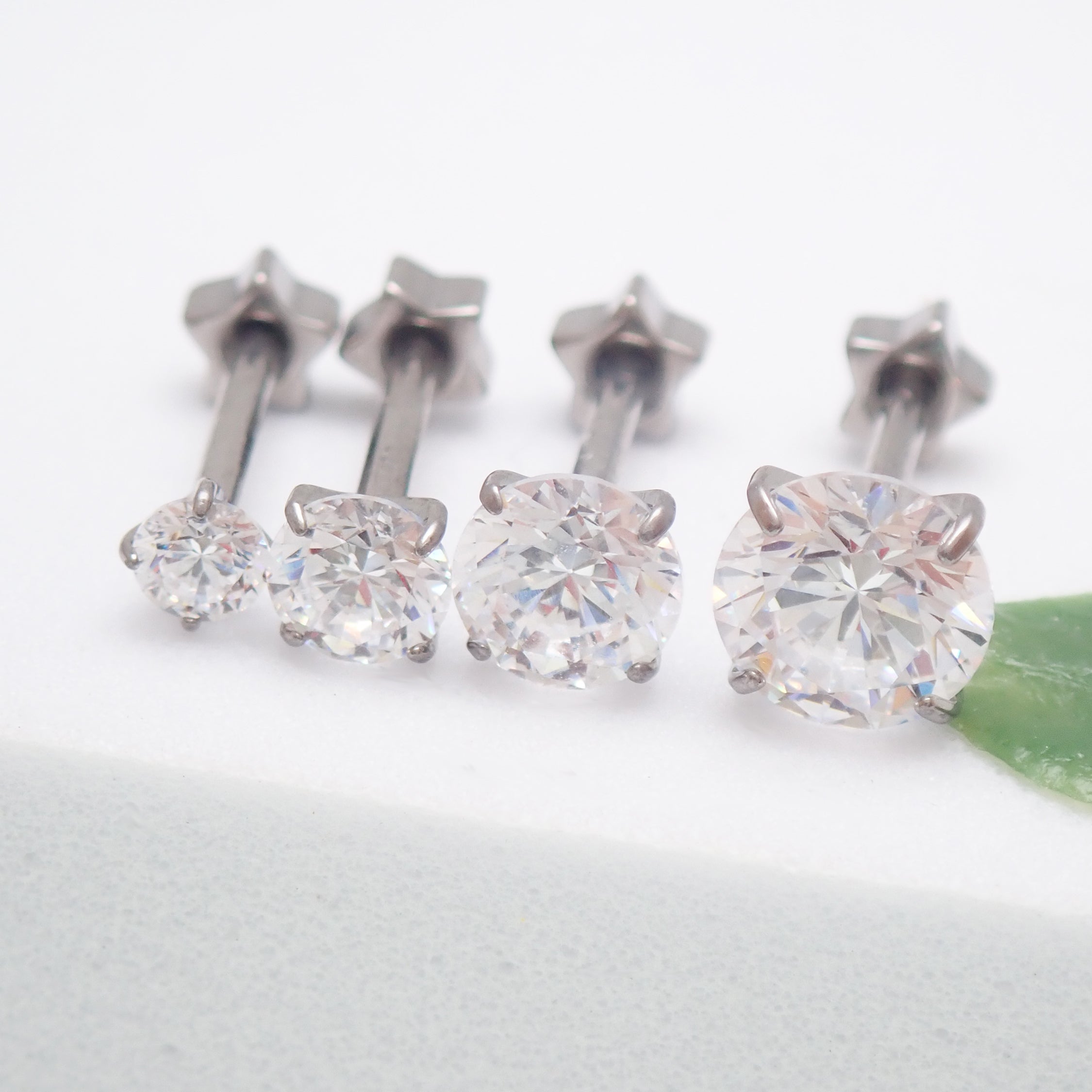 Set of 4 implant grade titanium star back CZ earrings, externally threaded, 16g 8mm, ideal for body piercing jewelry.