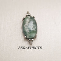 Titanium labret piercing earrings with oval natural seraphinite stone, available in 14g, 16g, and 18g sizes by Body Clickers.