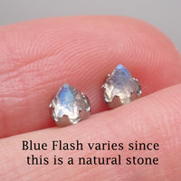 Pair of silver labradorite earrings displayed in a hand with a warning that the blue flash on the stone varies 