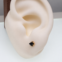 a gold onyx cone earring in a silicone ear model