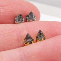 A pair of silver and Gold tourmalated quartz earrings displayed in between fingers
