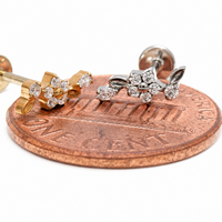 Dainty flower titanium flatback labret piercing earrings with 0.9mm threaded design, displayed next to a penny for size reference.