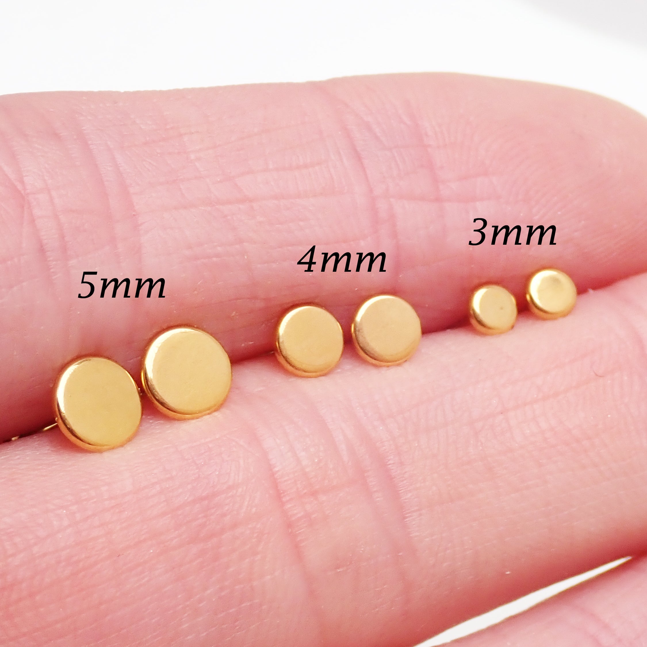 Pair of PVD gold titanium stud earrings featuring flat disc designs in 3mm, 4mm, and 5mm sizes, 20g.