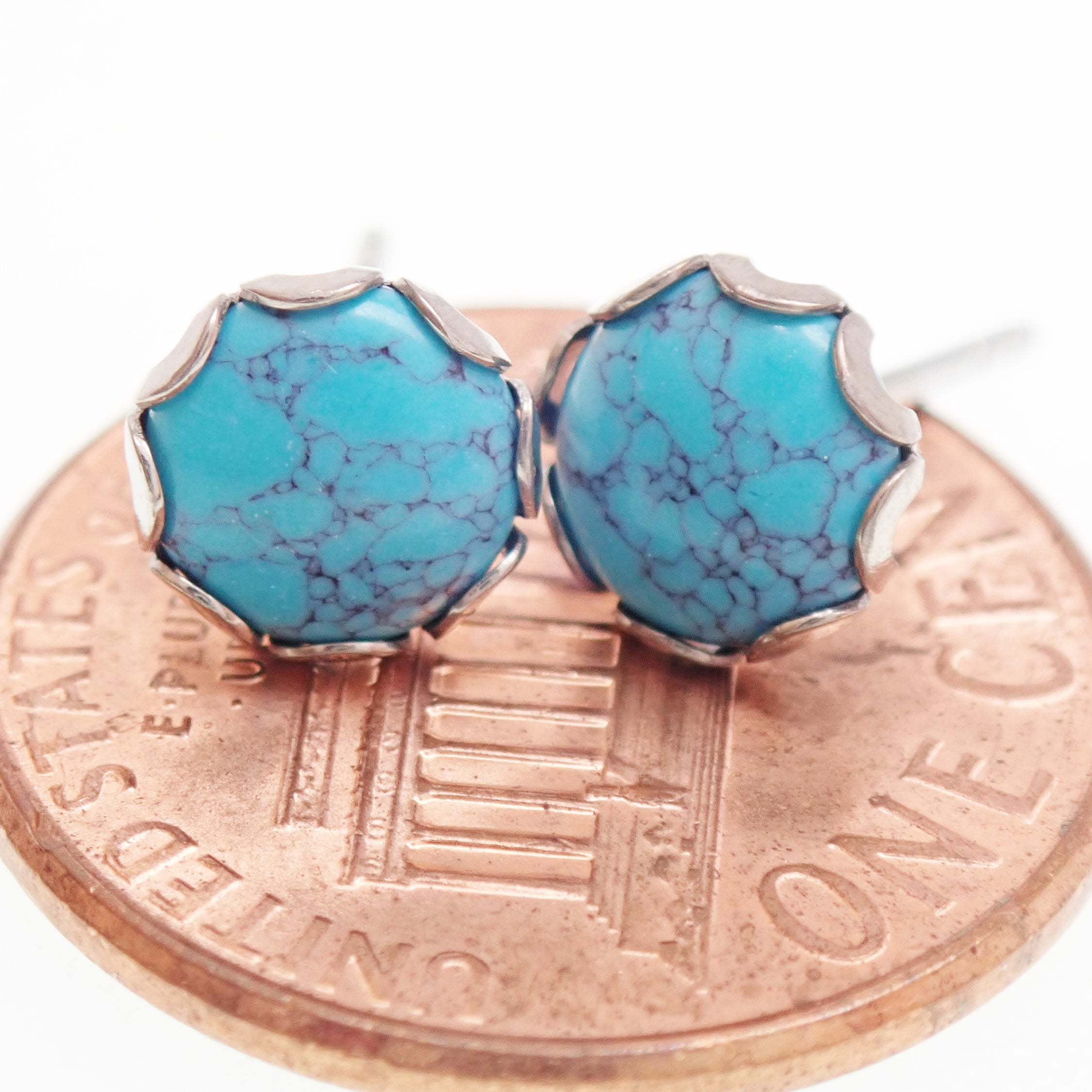 Pair of turquoise 6mm titanium stud earrings by Halobes, showing the smooth, round turquoise stones set in titanium posts.