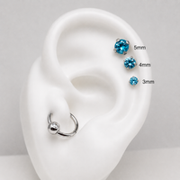Blue gemstone earrings on a white ear model with size measurements.