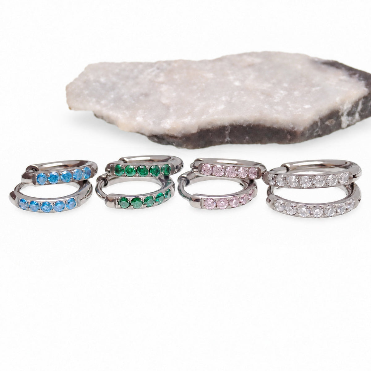 Titanium huggie earrings in blue, green, pink, and clear CZ