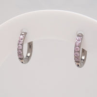 Titaniumm hoop earrings with pink CZ on a white display