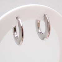 Silver titanium implant silhouette huggie earrings with hinged clicker closure, 10mm diameter, sold in pairs by Body Clickers.