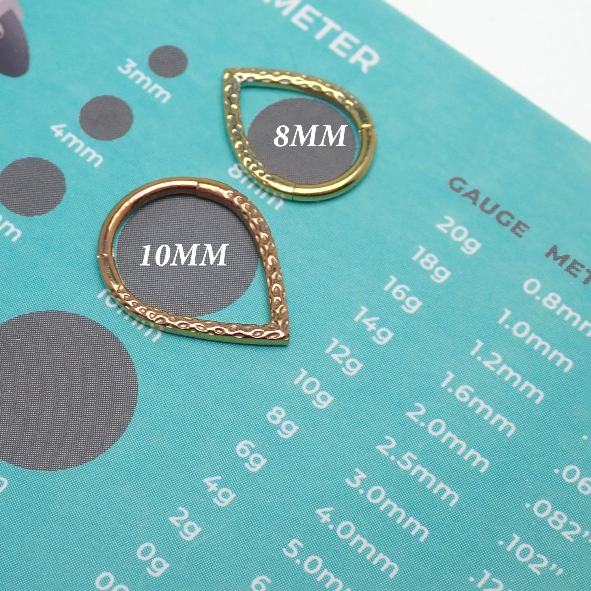 Hammered V Titanium Clicker in 8mm and 10mm sizes by Magpie, featuring textured hammered finish and sleek V-shaped design.