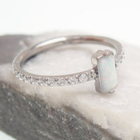 Rectangular white opal CZ titanium clicker earring in 16g size, 11mm, by Magpie Body Jewelry, shown in close-up.
