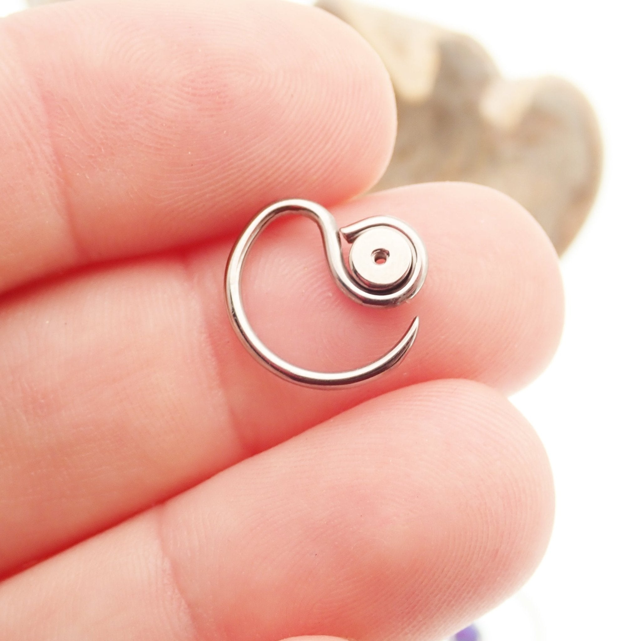 Niobium daith spiral body jewelry in 16g with customizable top design, featuring sleek, curved shape and smooth finish.
