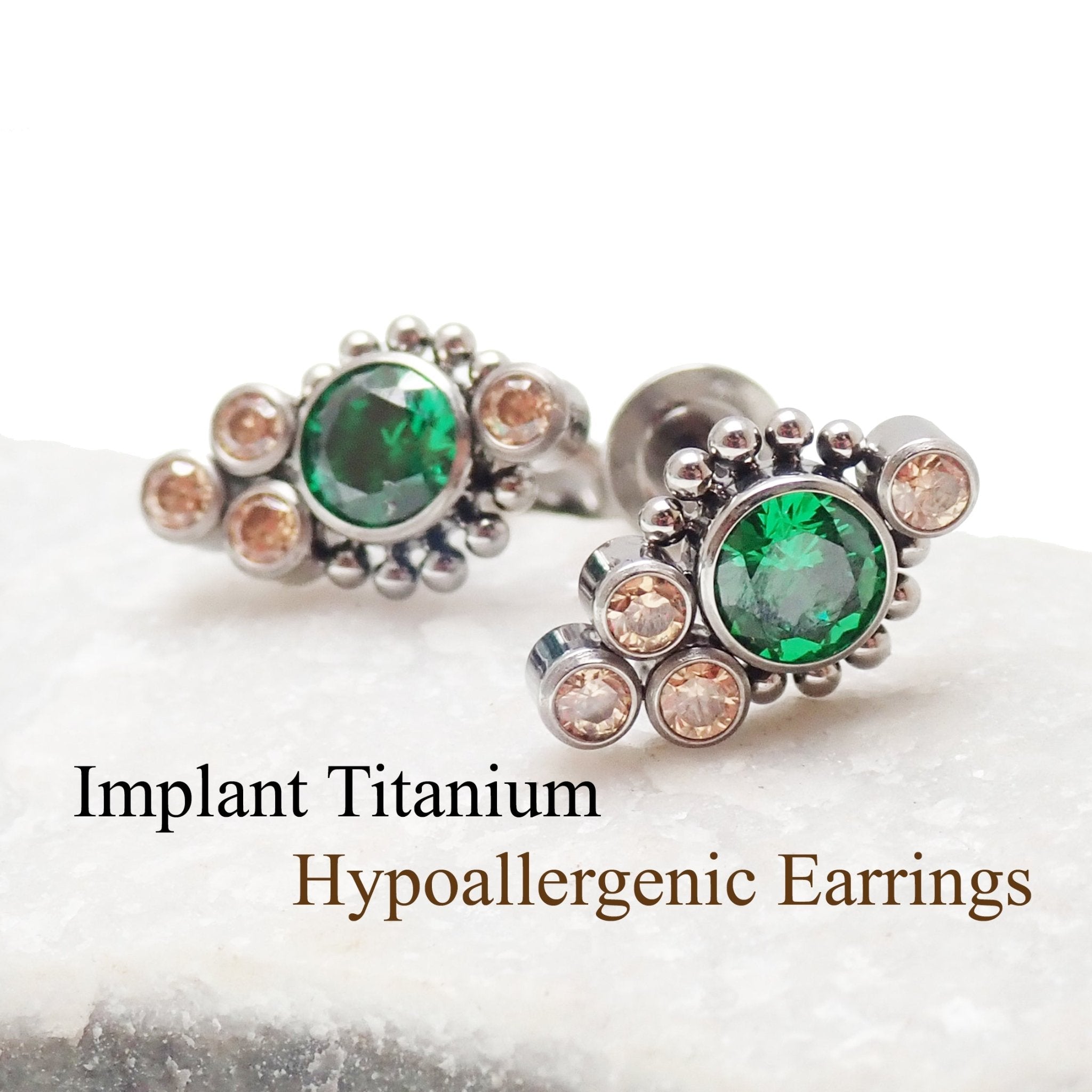 Titanium implant earrings with emerald and champagne-colored accents, 20g, showcasing sleek, modern jewelry design.