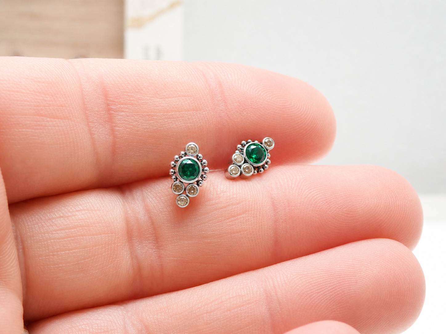 Titanium implant earrings with emerald and champagne-colored accents, 20g weight, stylish and modern jewelry design