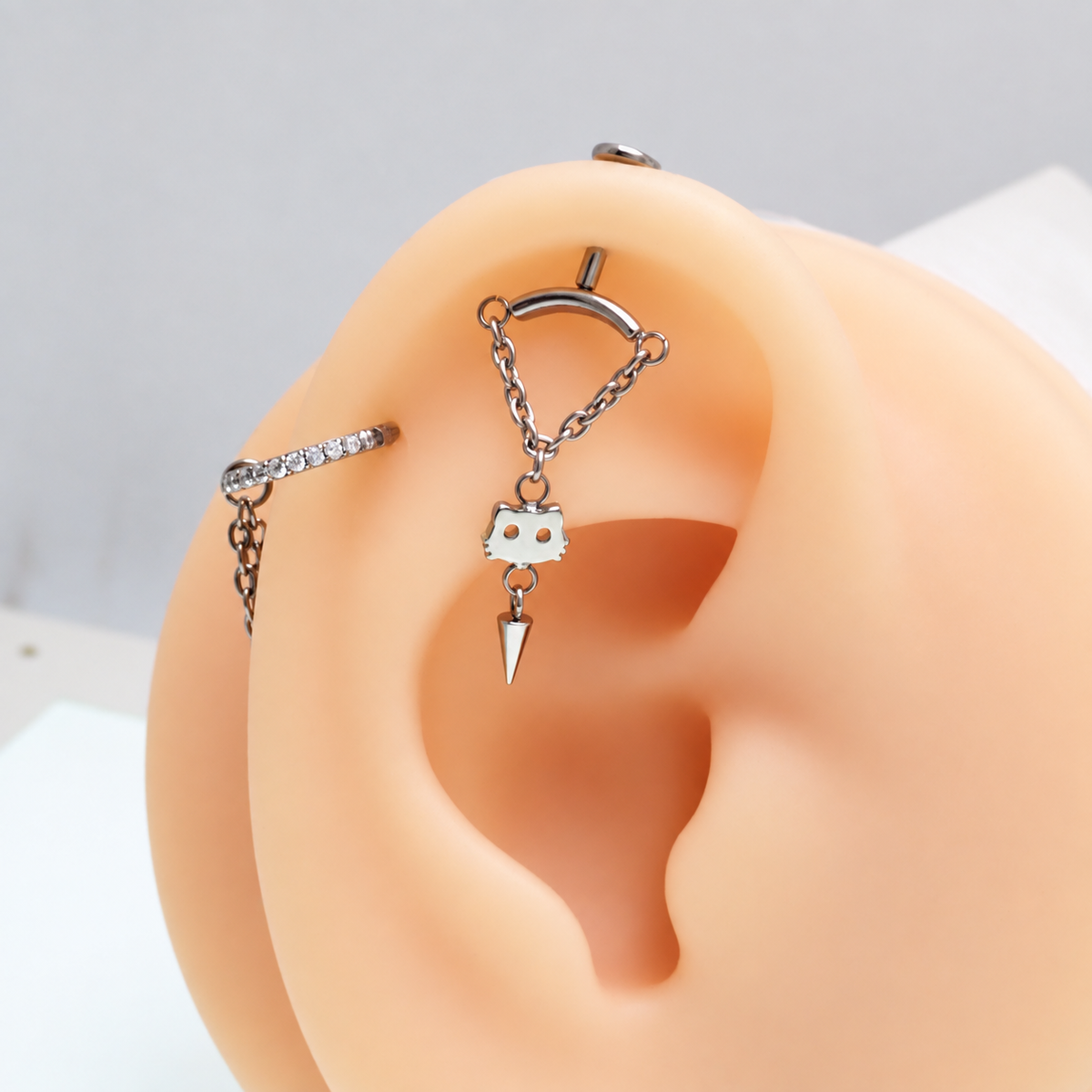 chain vertical helix with a dangly cat charm and a cone in a silicone model ear 
