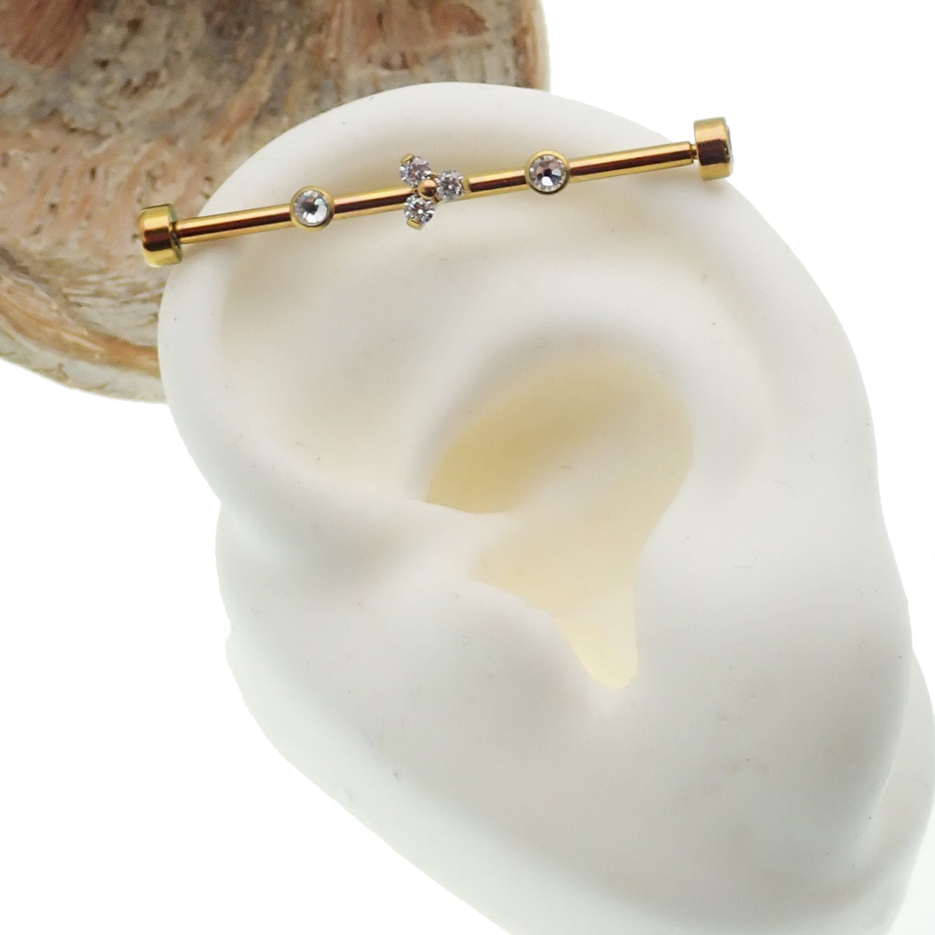 Gold industrial scaffold piercing with clear CZ and Trinity stones, 14g titanium bar from Body Clickers.