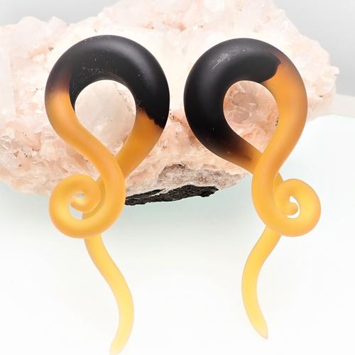 Pair of black and amber glass spirals earrings by Body Clickers, featuring 6mm diameter decorative spirals.