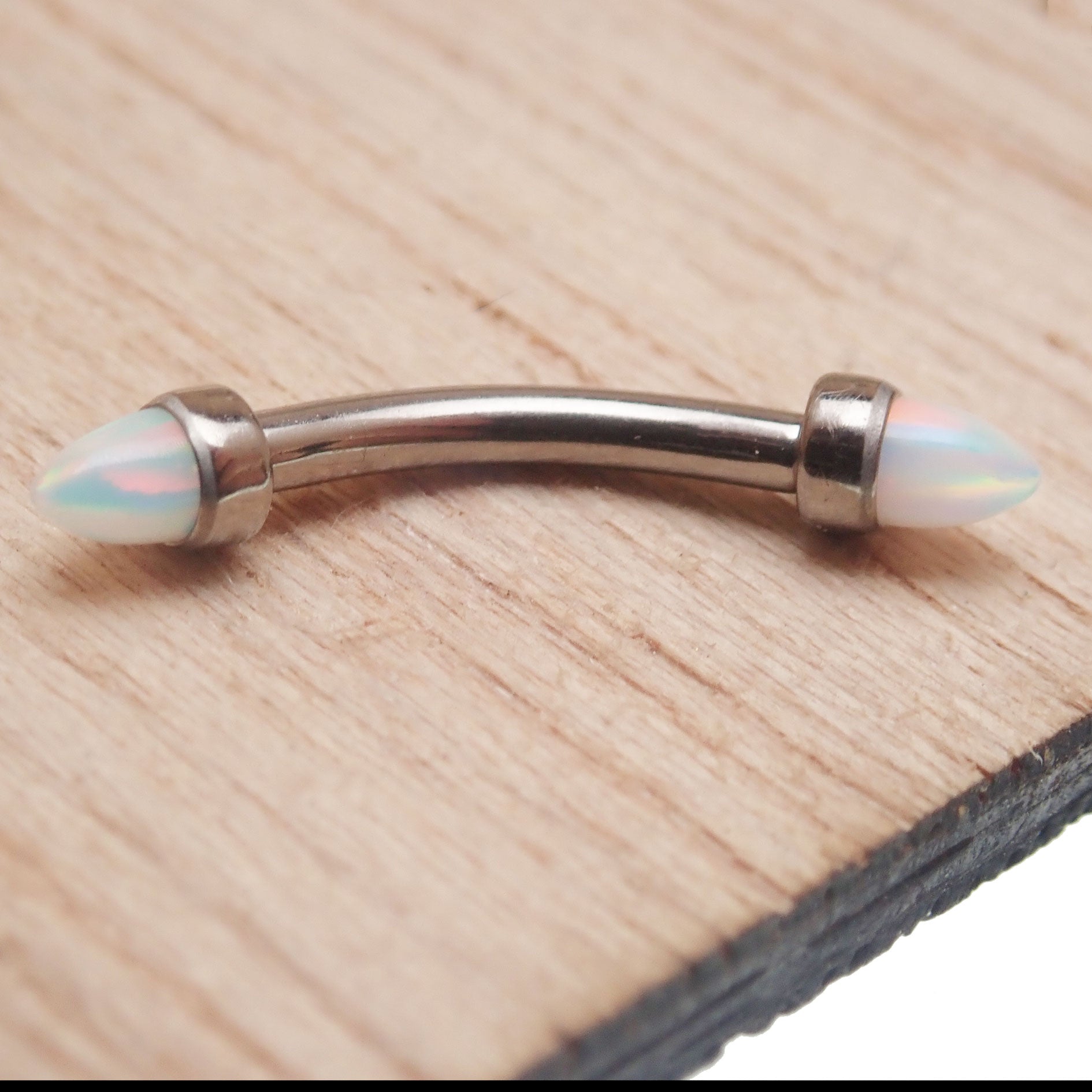 Black fire spiked opal cone with curved barbell piercing, 16g, from Body Clickers, jewelry for body adornment.
