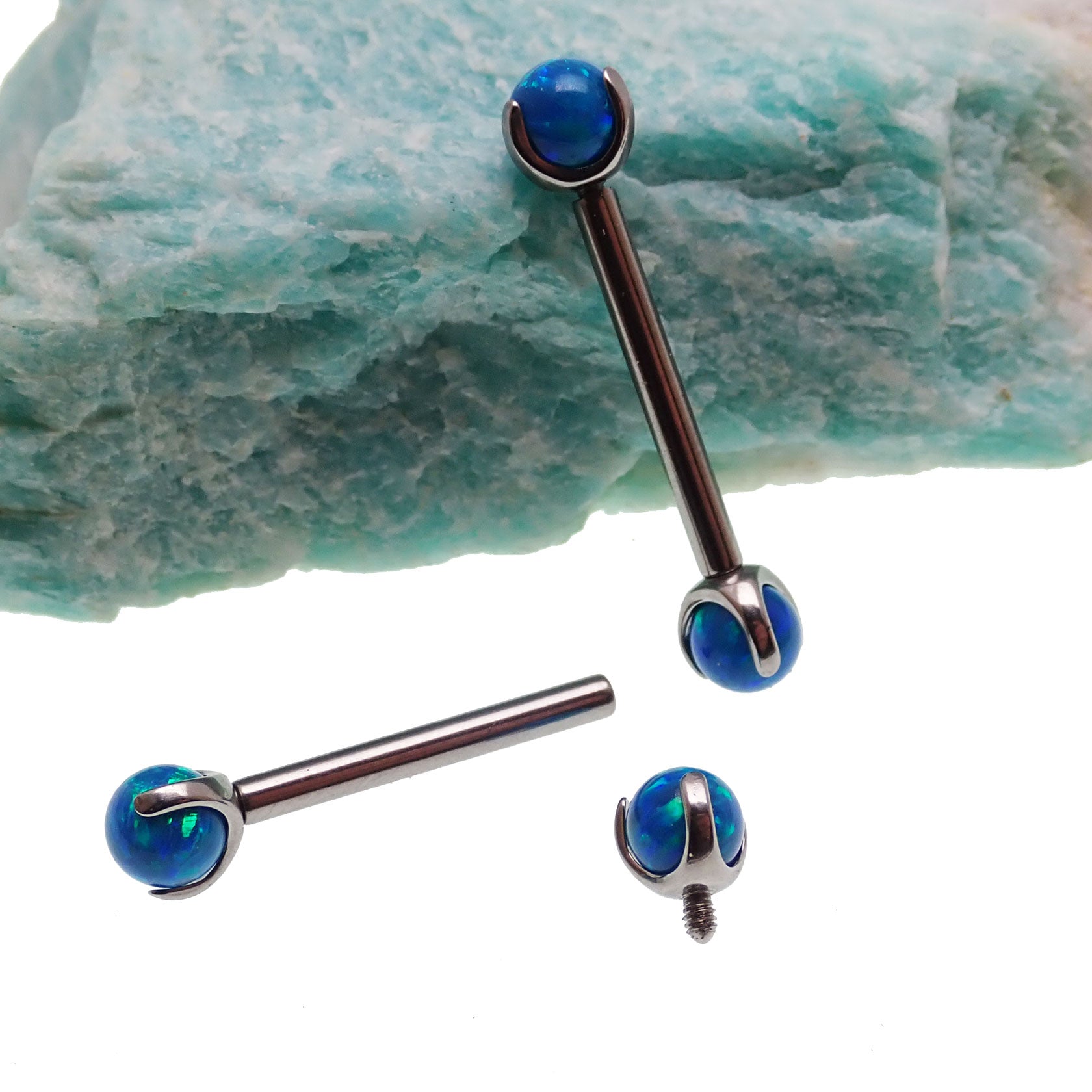 Peacock blue opal titanium nipple bar by Body Clickers Body Jewelry, 12g, 12mm curved bar with vibrant blue gem.