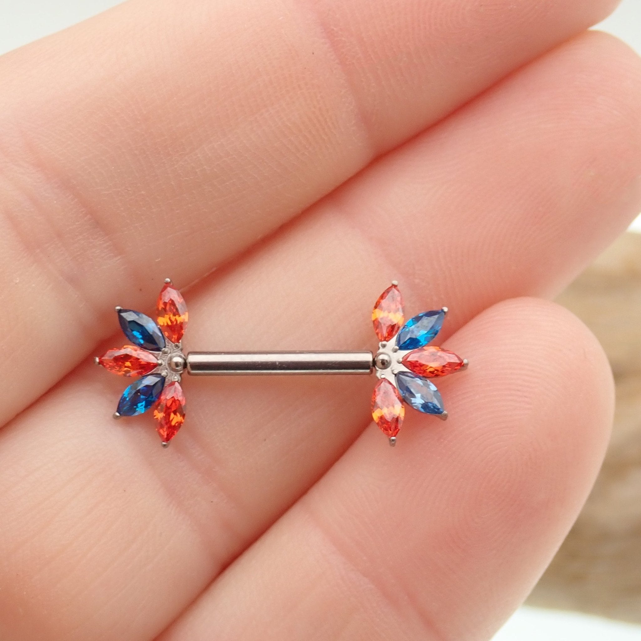 Orange and blue CZ flower titanium nipple bar in 12g, 14g, and 16g sizes, Body Clickers body jewelry with vibrant design