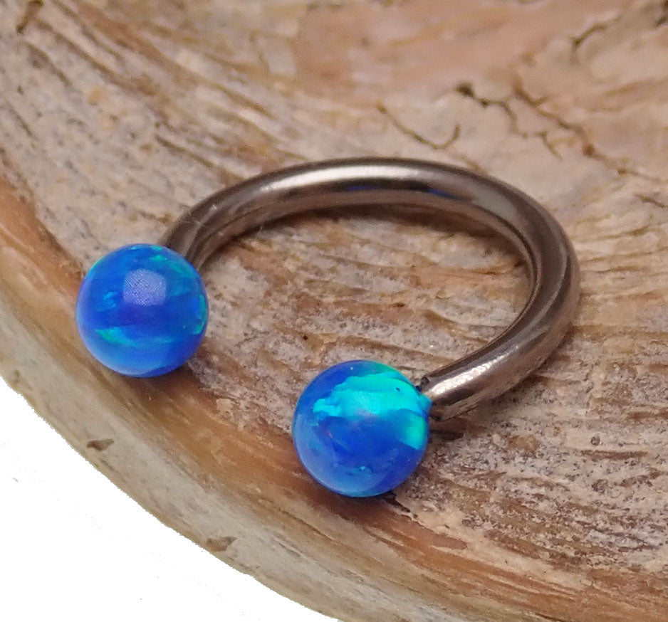 Body Clickers opal ends horseshoe body jewelry in 16g and 18g with yellow moon-shaped opal accents.