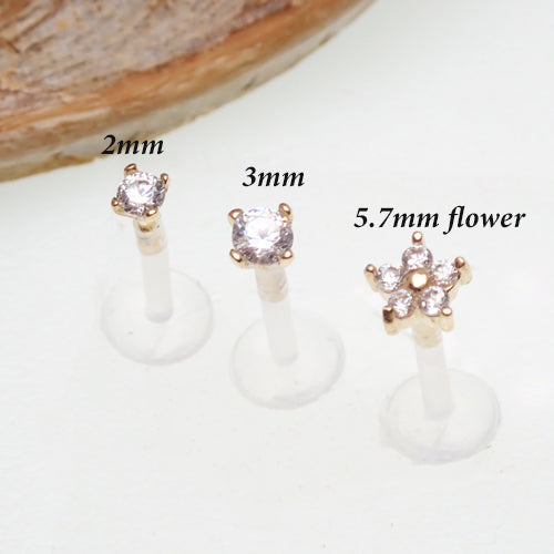 Gold push-fit flower body jewelry with CZ stones and bio-flex stems, designed for comfortable wear and elegant style.