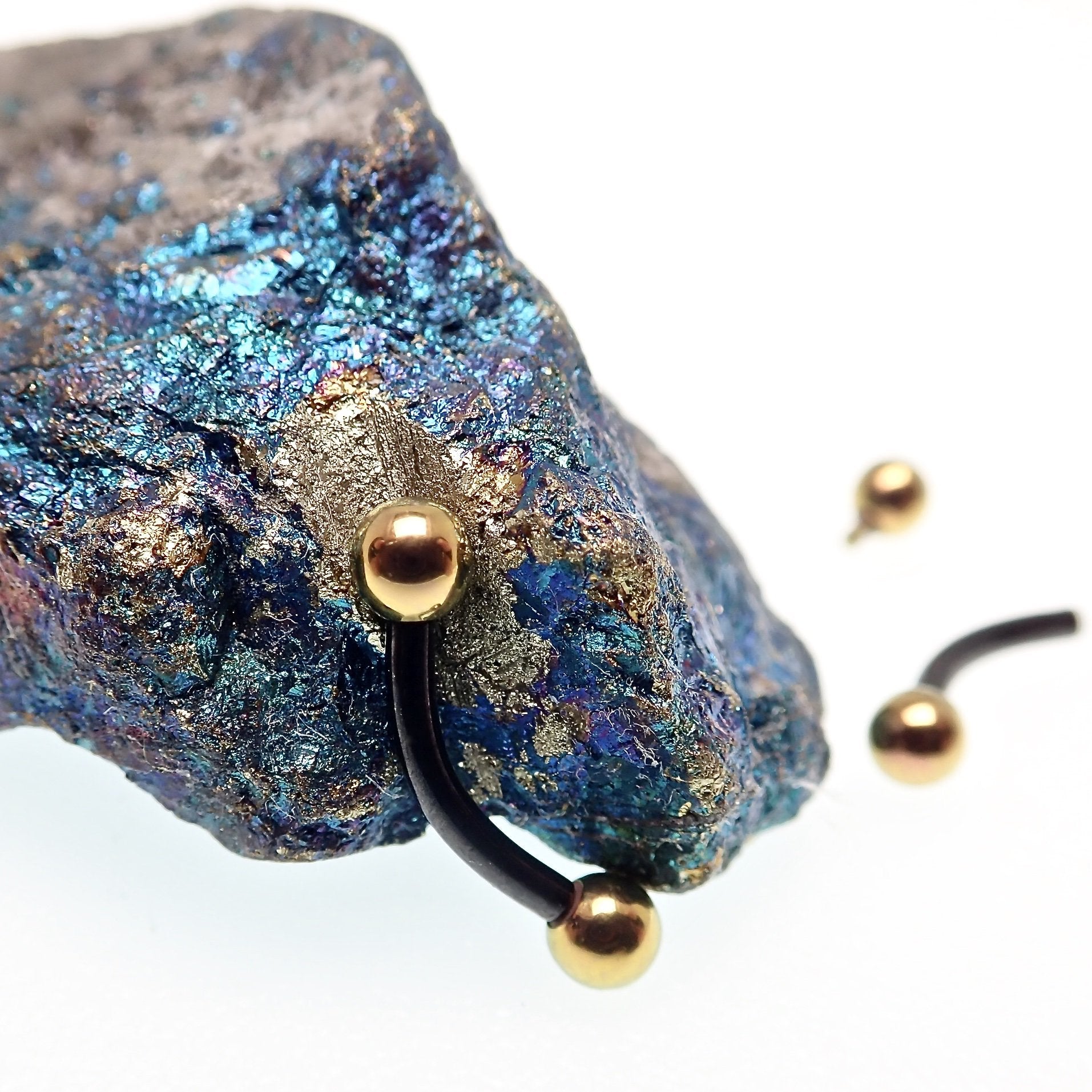 Black and gold titanium curved barbell ring, 16g internally threaded body jewelry with a sleek, polished finish.