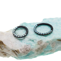 Rainbow AB CZ PVD black titanium clicker body jewelry in 16g with a 6mm diameter, featuring colorful cubic zirconia accents.