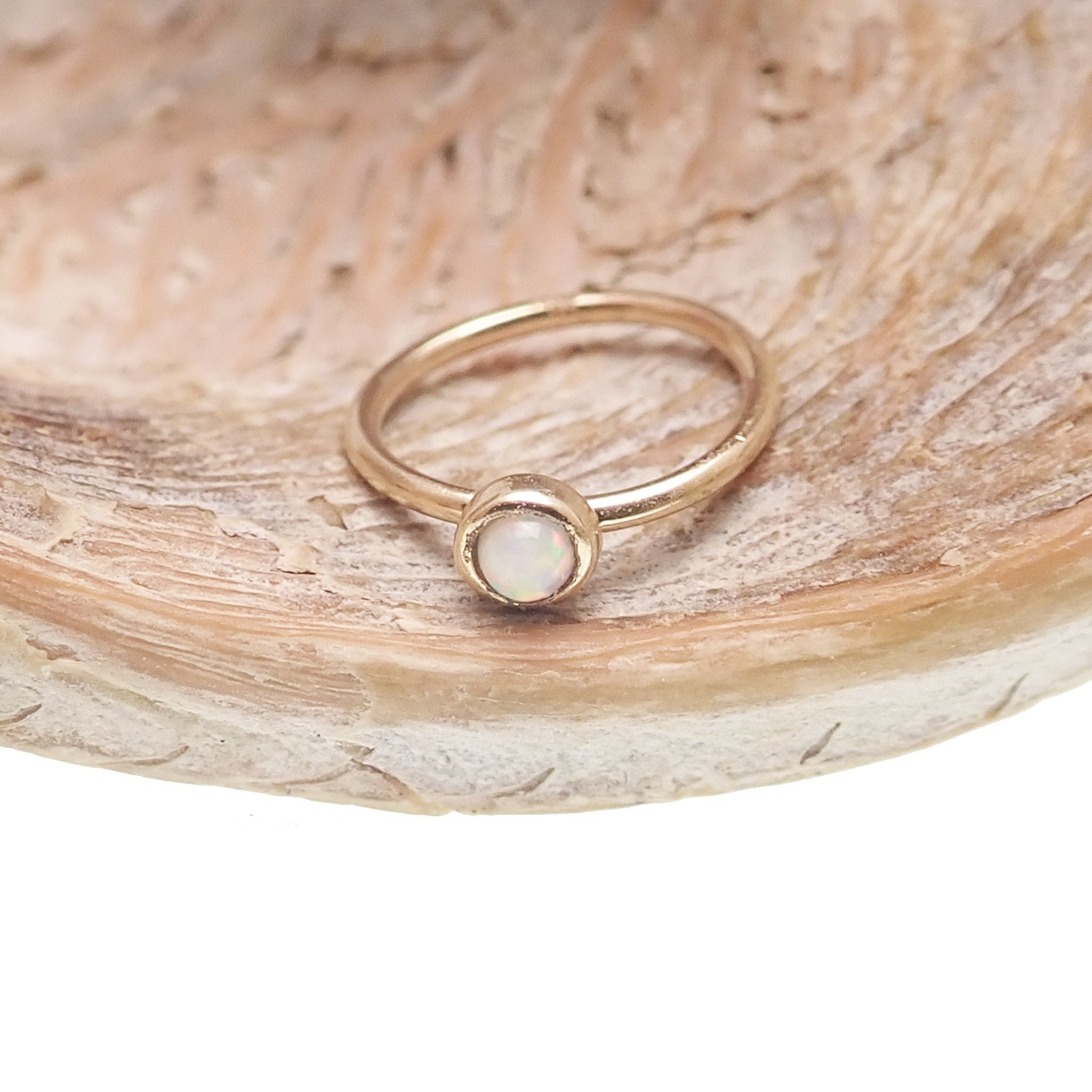 White opal seamless body jewelry ring in 14k gold, available in 6mm and 8mm sizes, by Body Clickers.