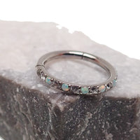 16G titanium clicker jewelry with an opal and cubic zirconia accents, showcasing a stylish body piercing accessory.